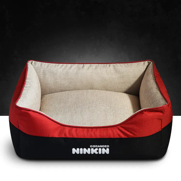 A red and beige removable washable dog bed with a non-slip bottom and plush interior, branded with the name NINKIN.