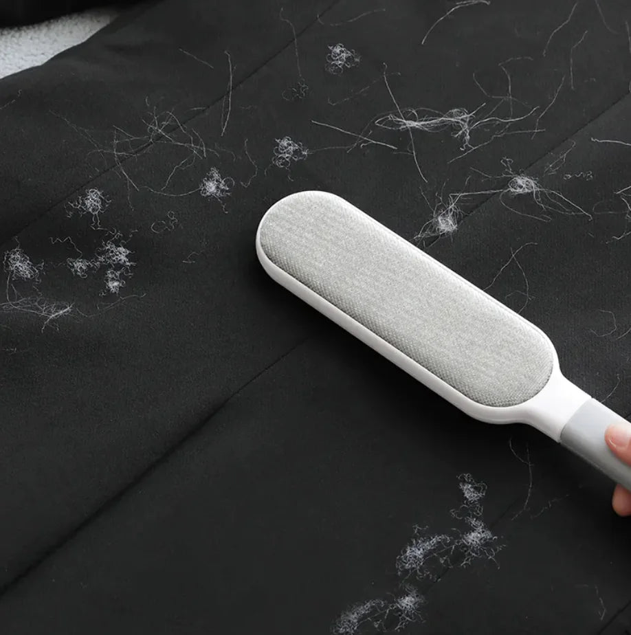Gray Electrostatic Hair Removal Brush removing pet hair from black fabric