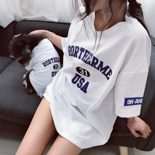 Pet parent and dog relaxing comfortably while wearing matching White (Pearl) cotton shirts with 'Rortherme USA' text in blue.