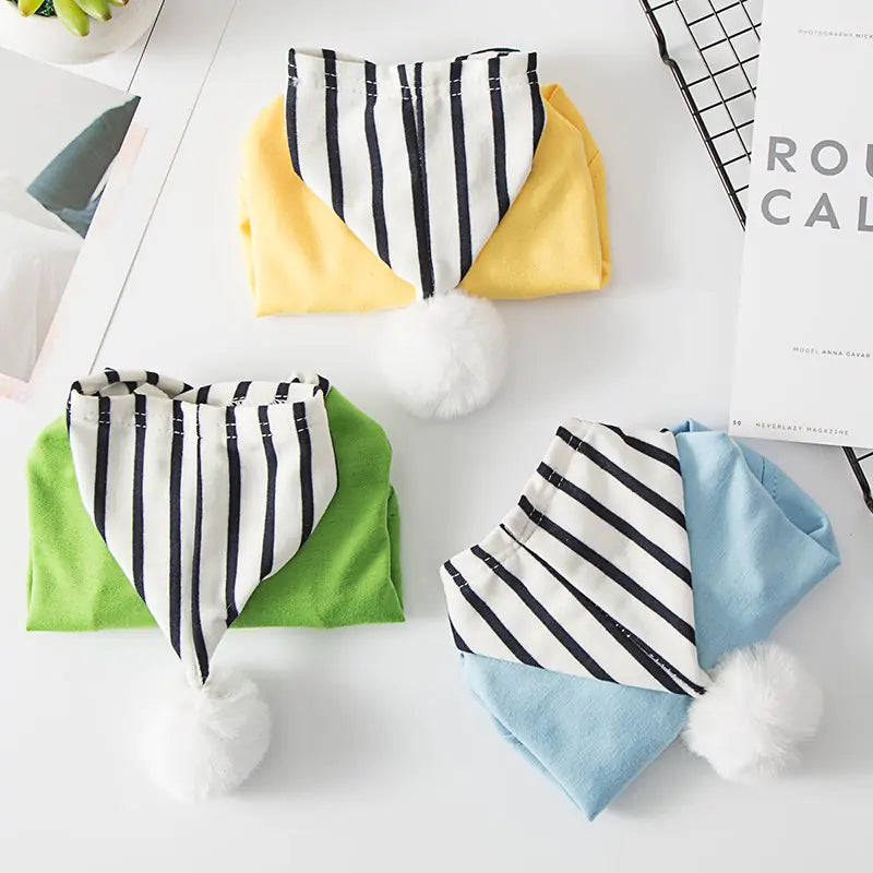 Three polyester pet hoodies with black and white striped hood and white pom-poms in three vibrant colors.
