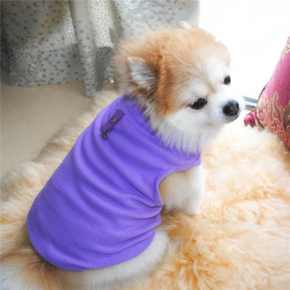 Small dog wearing vest harness on a white carpet. Made of soft polar fleece for your pet's warmth and comfort.