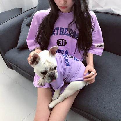 Pet parent and dog relaxing comfortably while wearing matching Purple (Lavender) cotton shirts with 'Rortherme USA' text written in blue.
