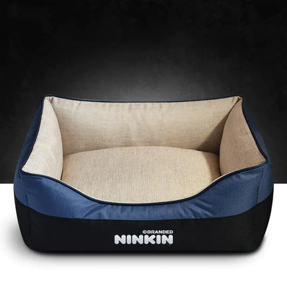 A blue and beige removable washable doggie bed with a non-slip bottom and plush interior, branded with the name NINKIN.