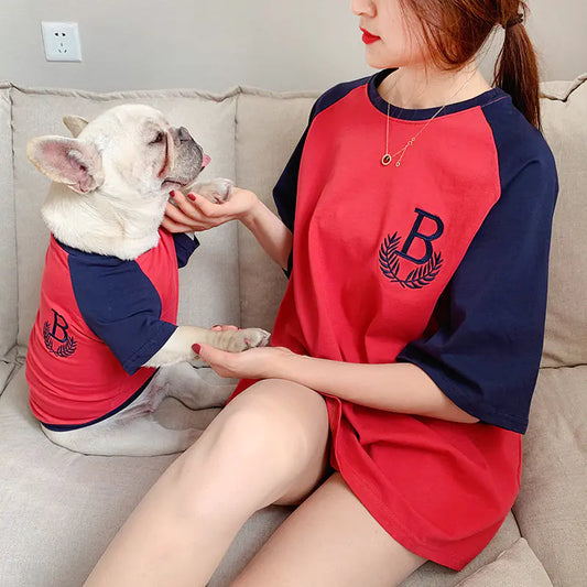 Pet parent and dog relaxing comfortably while wearing matching Red (Ruby) and blue cotton shirts.