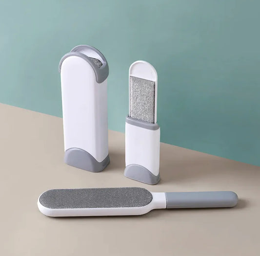 Three Electrostatic Hair Removal Brushes on a beige surface with a green background