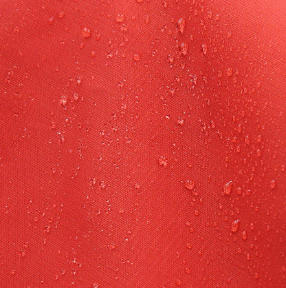 Red fabric with water droplets on a close-up view showing how the material repels water.