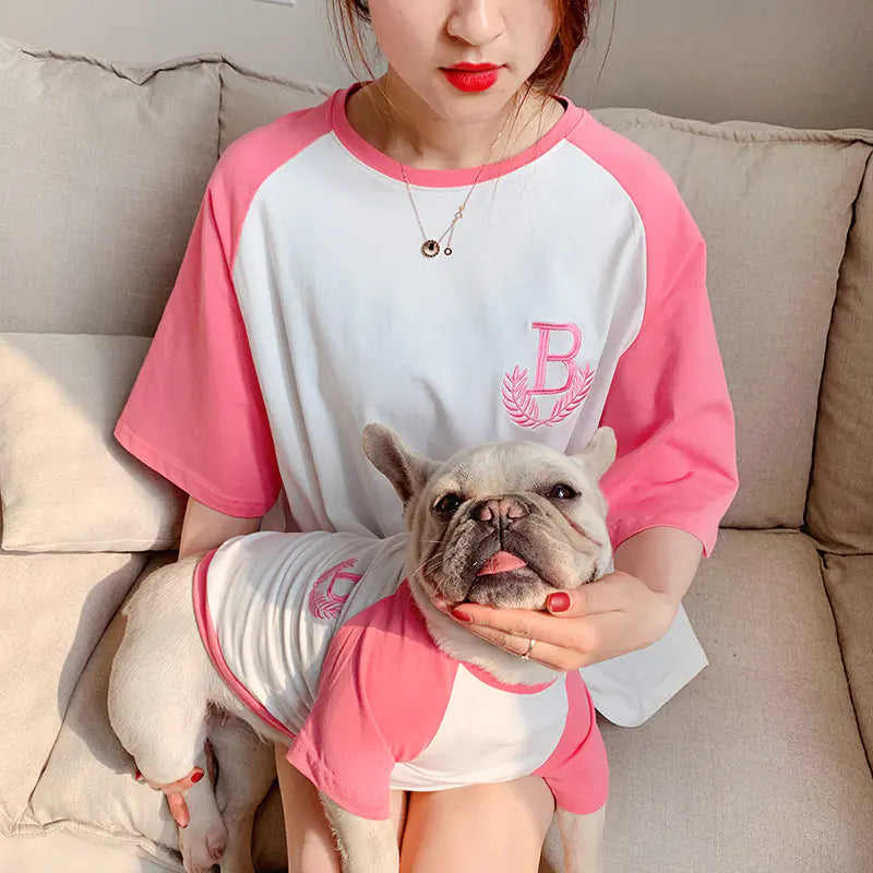 Pet parent and dog relaxing comfortably while wearing matching Pink (Bubblegum) and white cotton shirts.