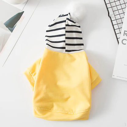 Yellow (Sunshine) polyester pet hoodie with black and white striped hood and white pom-pom, cozy and comfortable for a fun dog walk.