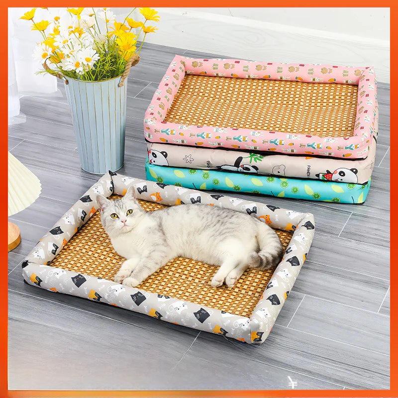 Cat lying on a gray patterned pet cooling bed with other similar beds stacked in the background.