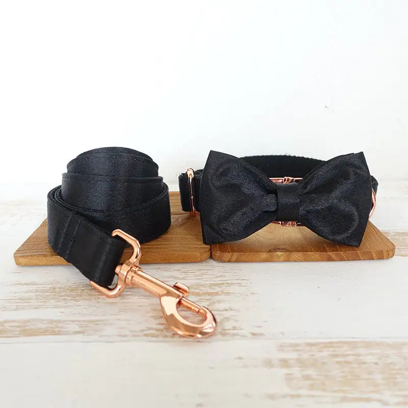 Stylish doggie Black (Midnight) bow tie on a wooden block with a light wood background with rose gold matching leash