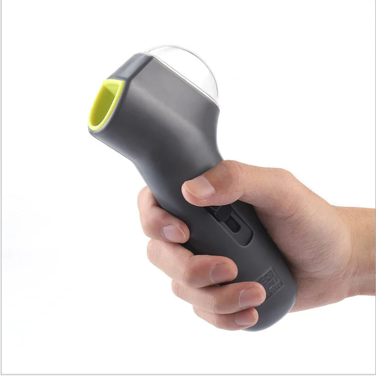 Gray (Mist) colored pet treat launcher being held by the dog owner and preparing to launch tasty dog treats.