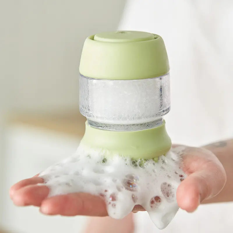 Green (Spring) silicone dog brush shown filled with suds being held in the dog owners hand.