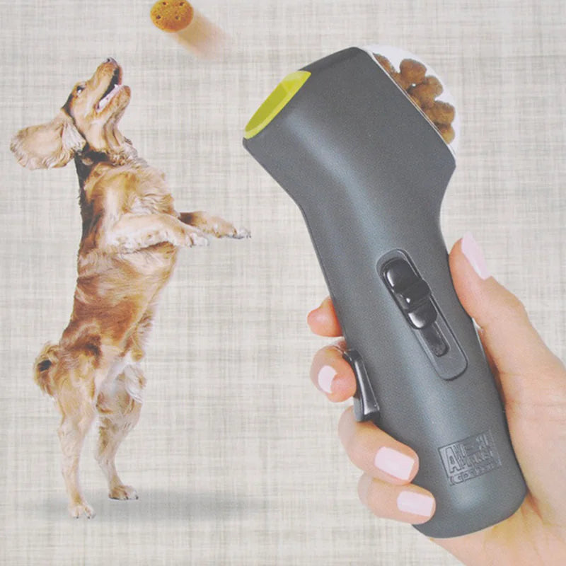 Gray (Mist) colored doggie treat launcher being held by the dog owner and launching dog treats to an eager pet.