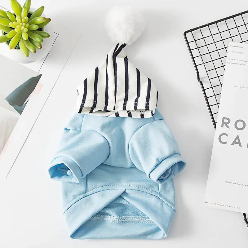 Light Blue (Sky) polyester pet hoodie with black and white striped hood and white pom-pom, cozy and comfortable for a fun dog walk.
