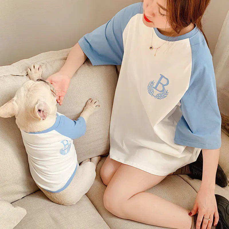 Pet parent and doggy relaxing comfortably while wearing matching Light Blue (Sky) and white cotton shirts.
