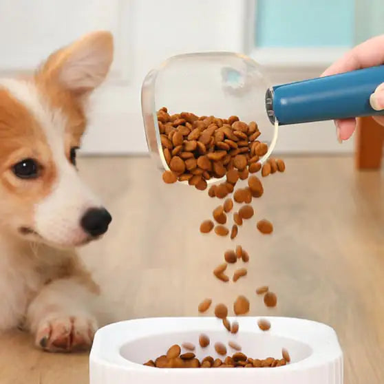 Dog watching as kibble is poured  into a bowl using a clear measuring scoop with with a Blue (Ocean) handle.
