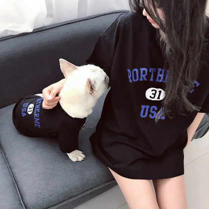 Pet parent and doggie relaxing comfortably while wearing matching Black (Midnight) cotton shirts with 'Rortherme USA' text written in blue.